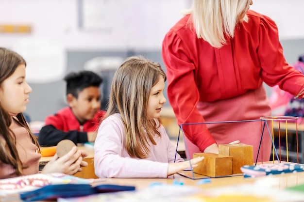 Un insegnante che mostra le forme degli alunni durante la lezione di geometria