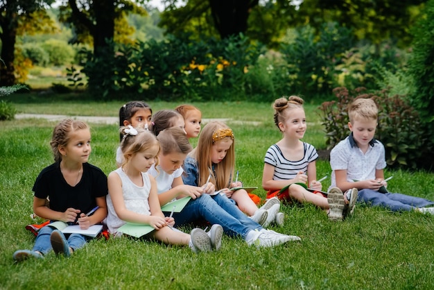 Un insegnante insegna a una classe di bambini in un parco all'aperto