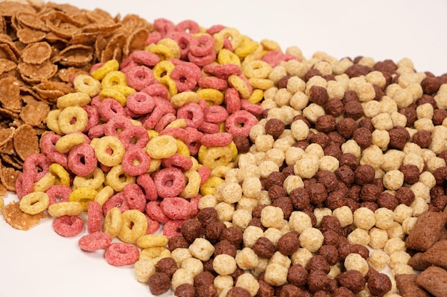 Un insieme di diversi cereali per la colazione veloce anelli e palline vista dall'alto su bianco