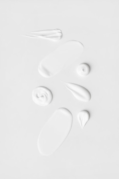 Un insieme di diversi tratti di crema bianca su sfondo chiaro