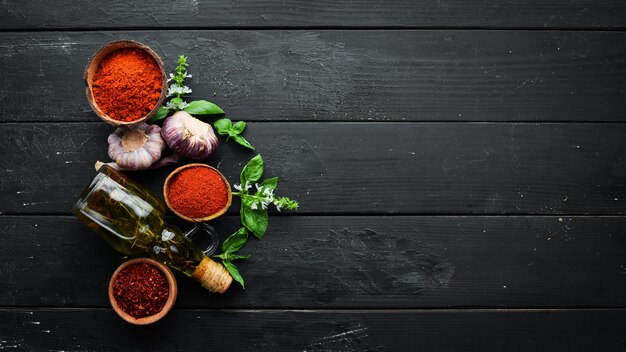 Un insieme di spezie rosse su sfondo nero Peperoncino Paprika Vista dall'alto