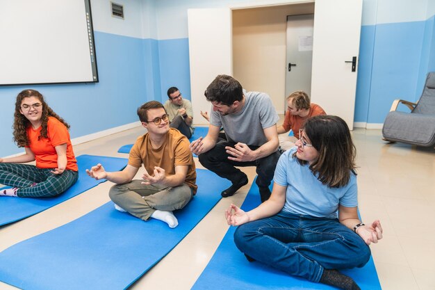 Un istruttore di yoga compassionevole interagisce con uno studente con la sindrome di Down