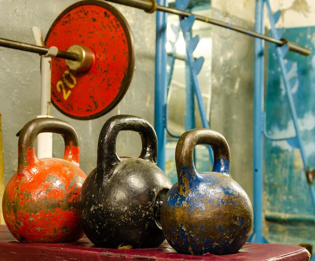 Un kettlebell rosso, blu e arancione è seduto accanto a un kettlebell rosso e blu.