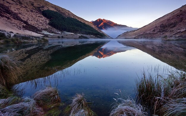 un lago con una montagna sullo sfondo e una montagna nello sfondo