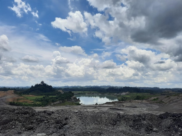 un lago formato da ex scavi minerari con un cielo azzurro nuvoloso sullo sfondo