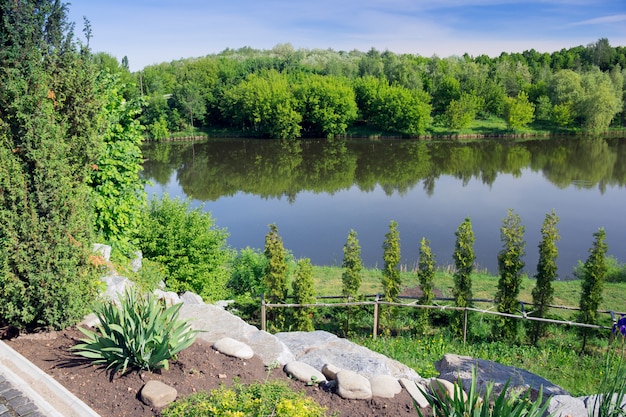 Un lago nel mezzo di un giardino verde e una foresta