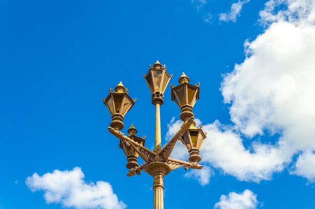 Un lampione con un cielo azzurro e nuvole sullo sfondo