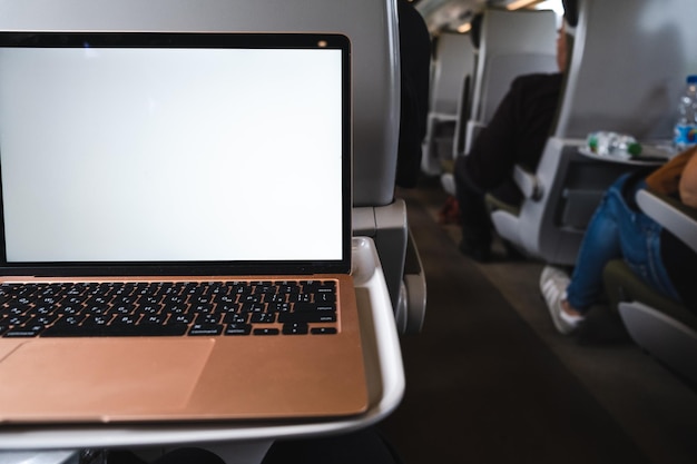 Un laptop con uno schermo bianco è seduto su un tavolo in un treno