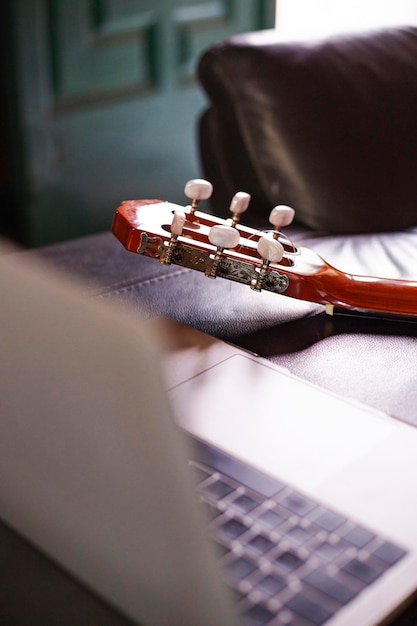 Un laptop sul divano per imparare a suonare la chitarra online