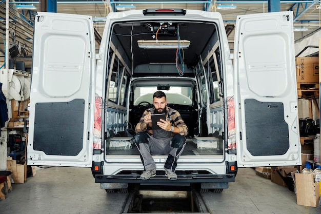 Un lavoratore del settore che controlla la costruzione di autobus nella fabbrica di produzione di veicoli