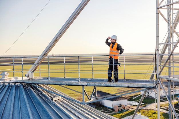 Un lavoratore del settore si guarda intorno mentre si trova in cima al silo