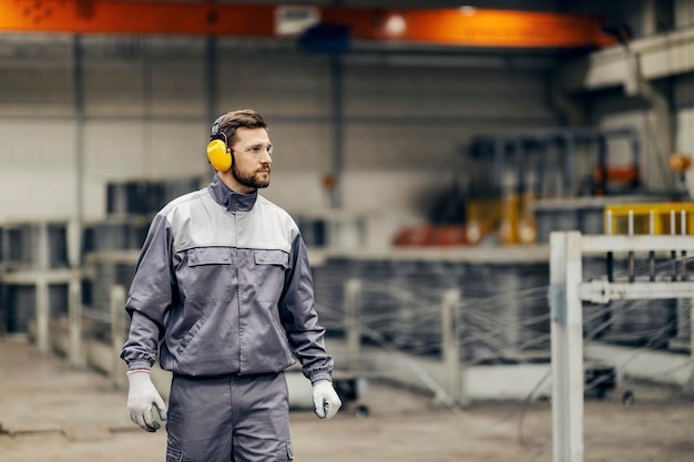 Un lavoratore dell'industria pesante sta camminando per la struttura e sta andando al suo posto di lavoro