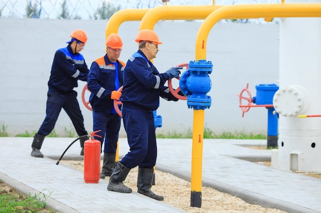 Un lavoratore in uniforme apre una valvola per controllare i gas
