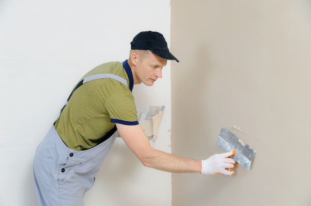 Un lavoratore sta intonacando un muro.