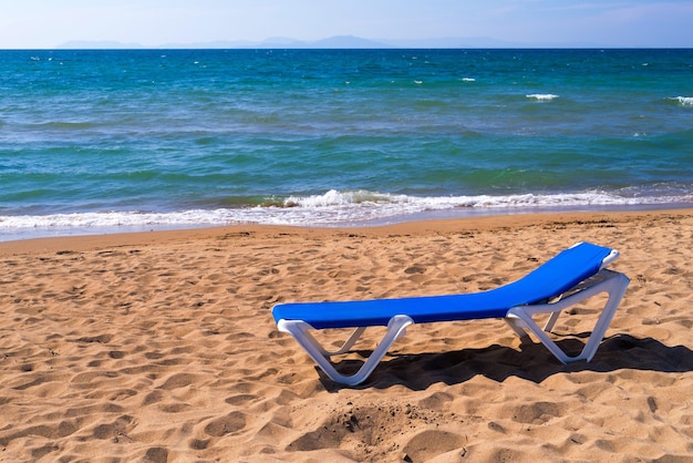 Un lettino per l'abbronzatura si trova in primo piano sulla spiaggia sabbiosa e l'orizzonte in lontananza