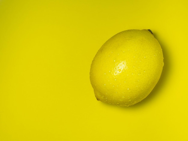 Un limone intero su sfondo giallo Agrumi sul tavolo Sfondo luminoso Sano cibo fortificato per un prodotto vegetariansour