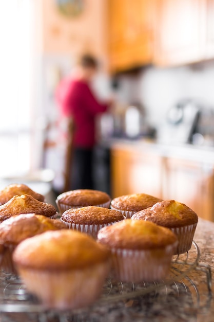 Un lotto di cupcake o muffin appena cucinati in casa che si raffreddano su un rack di filo in cucina