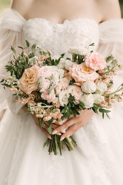 Un lussuoso bouquet da sposa a forma di cuore nelle mani della sposa