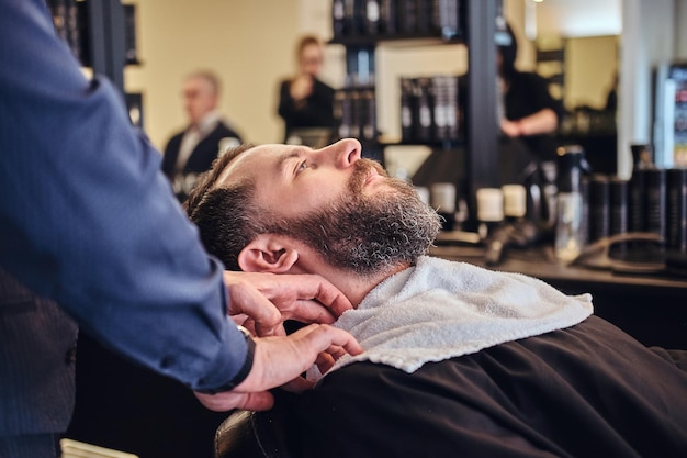 Un maestro parrucchiere prepara il viso per la rasatura nel negozio di barbiere.