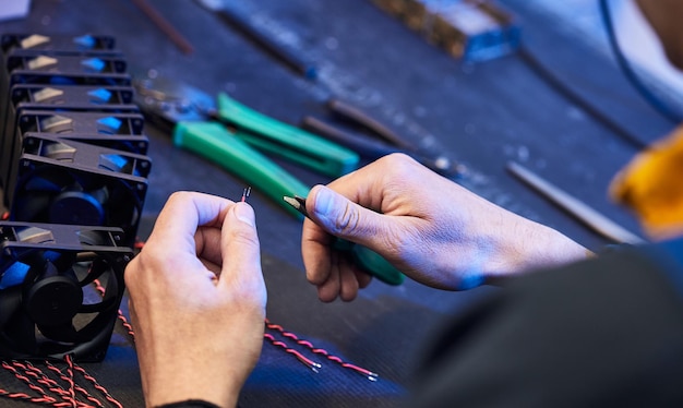 Un maestro tecnologo crea ventole per un sistema di raffreddamento del computer Le parti della ventola del computer giacciono sul tavolo