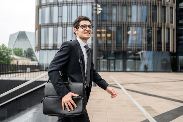 Un manager maschio va a lavorare in ufficio in completo con una valigetta