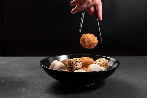 Un mans mano con le bacchette prende una cucina giapponese mochi dessert asiatico