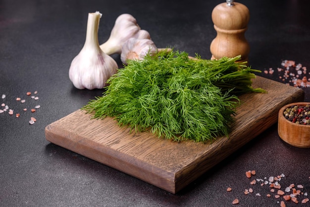 Un mazzo di aneto verde fresco su un tagliere di legno