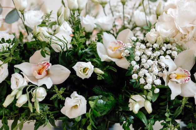 Un mazzo di fiori con fiori bianchi e foglie verdi