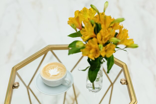 Un mazzo di fiori gialli Un vaso di vetro Una tazza di caffè Lavoro