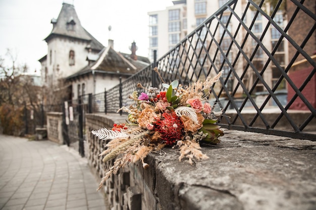 Un mazzo di fiori si trova su un muro di pietra di fronte a un edificio.