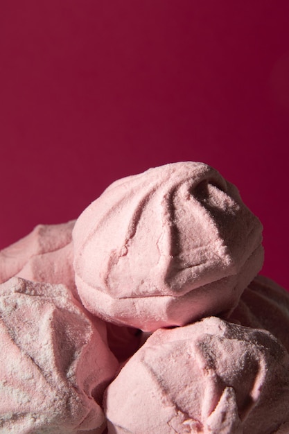 Un mazzo di marshmallow rosa su sfondo rosa Primo piano verticale