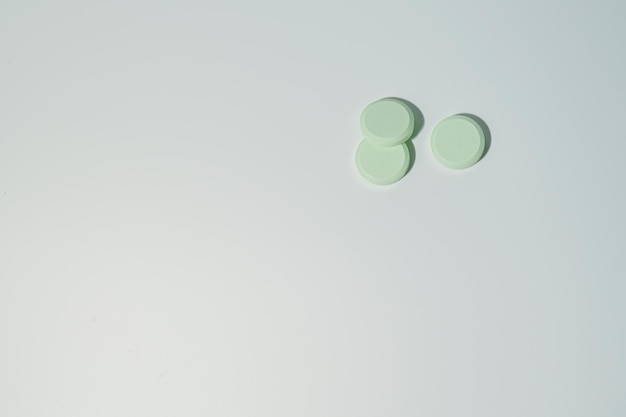 Un mazzo di pillole medicinali e antibiotici, compresse mediche bianche, verde chiaro, con spazio per la copia