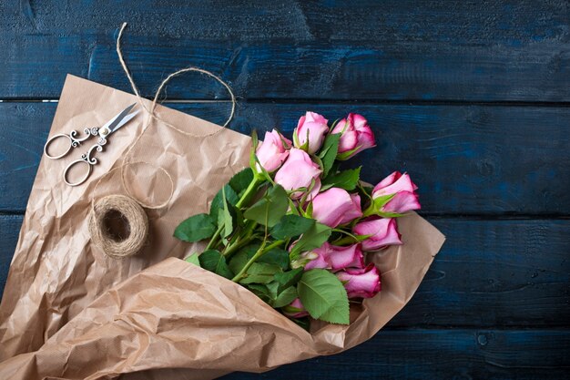 Un mazzo di rose rosa in carta marrone. Maccheroni di pasta di colore