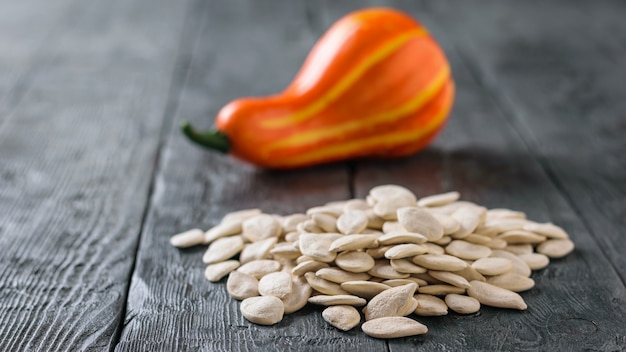 Un mazzo di semi di zucca e un piccolo frutto sul tavolo del villaggio