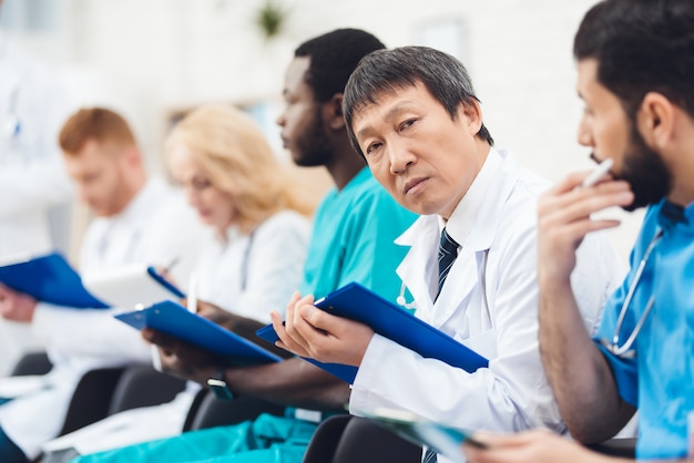 Un medico asiatico guarda la telecamera.