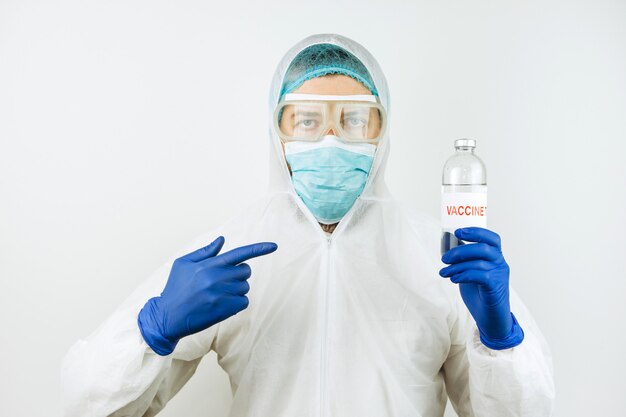 Un medico in camice bianco e guanti blu tiene una provetta per siringa con un vaccino contro il coronavirus. Iniezione di vaccino Covid 2019. 2020 coronavirus pandemico. Test del vaccino.