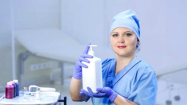 Un medico in guanti medici tiene in mano un antisettico. Foto orizzontale