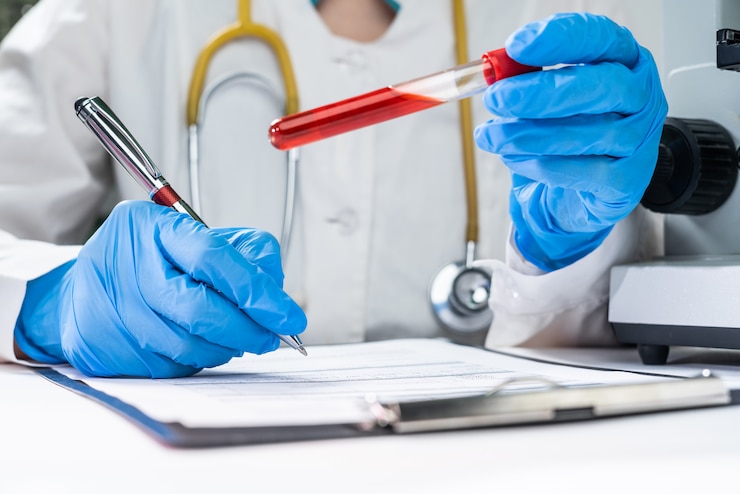 Foto un medico in un laboratorio detiene una provetta con un esame del sangue dei pazienti. registra la diagnosi sul modulo paziente