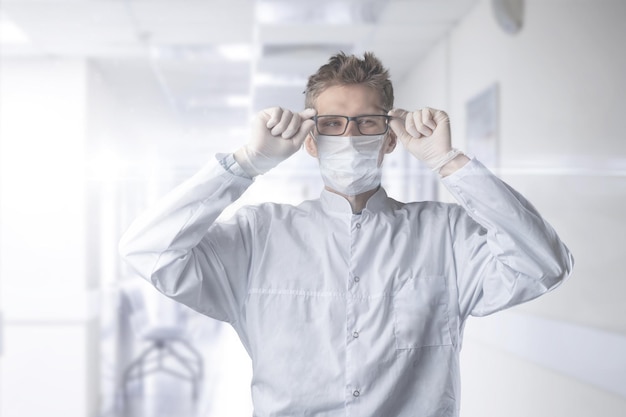 Un medico maschio ha indossato un'uniforme protettiva con maschera e occhiali in ospedale