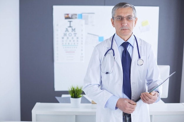 Un medico maschio scrive appunti sulla scheda dell'ospedale.