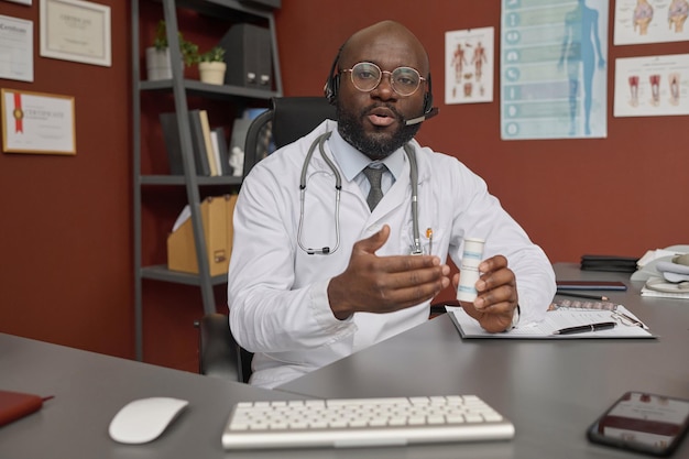 Un medico prescrive un farmaco al suo paziente durante una videoconferenza