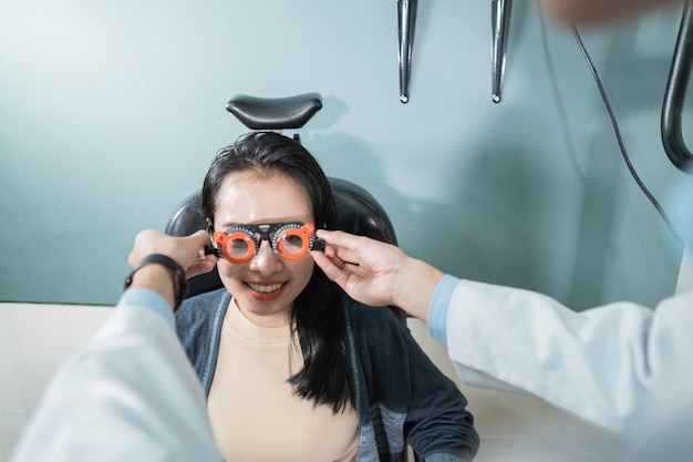 Un medico sta usando misurini per una paziente in una stanza in una clinica oculistica