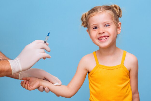 Un medico vaccina una bambina bionda