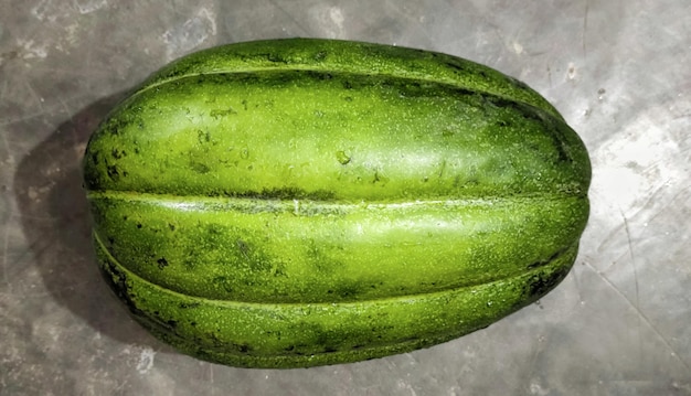 Un melone verde si trova su un melone da banco