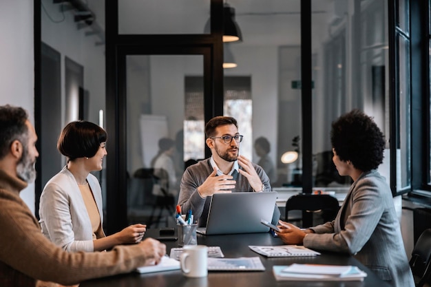 Un mentore dedicato spiega ai mentee l'importanza del progetto mentre è seduto in sala riunioni