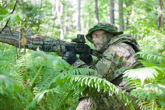 Un militare nella foresta durante l'esercizio. Mitragliatrice e vestiti del soldato