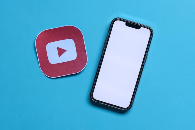 Un mockup di smartphone con schermo vuoto con carta stampata del logo dell'applicazione di social media denominato Youtub