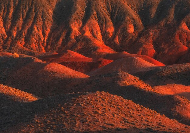 un modello astratto di montagne sabbiose e desertiche di colore mattone al tramonto