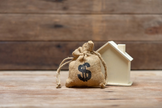 Un modello di casa modello è posto su una pila di coins.using come concetto di business di sfondo