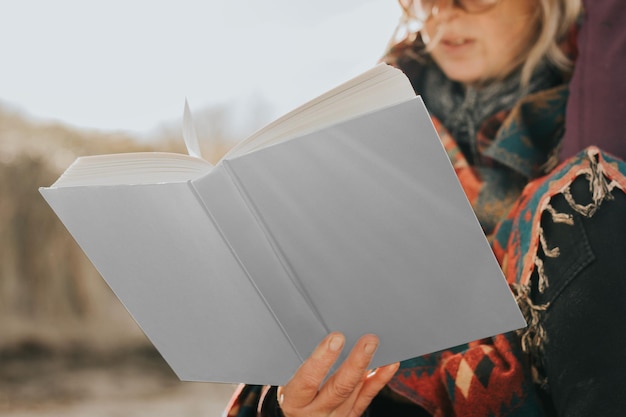 Un modello di libro png tenuto da un anziano in pensione sulla spiaggia